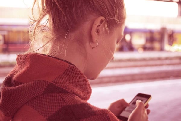 mulher caminhando e olhando o celular